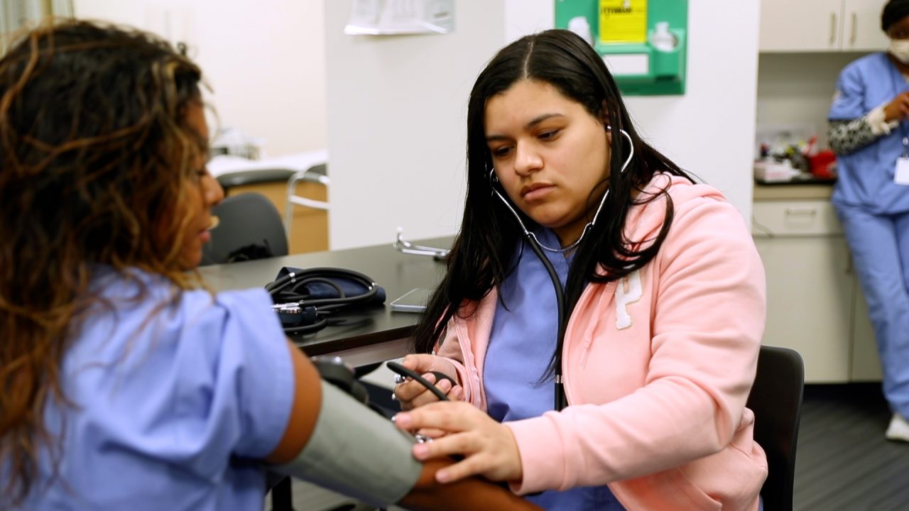medical assisting student measuring blood pressure