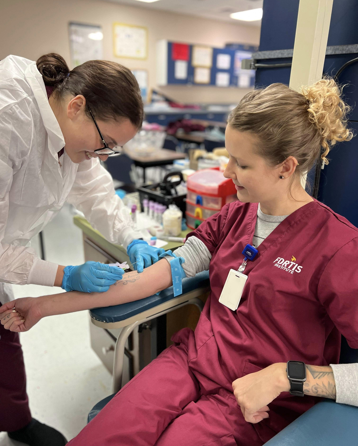 Healthcare professional draws blood from seated patient