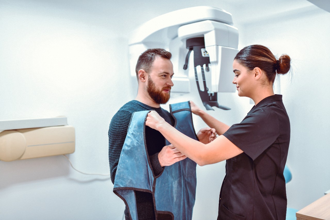 Female Dental Radiologist Preparing Male Patient For Dental Computer Tomography