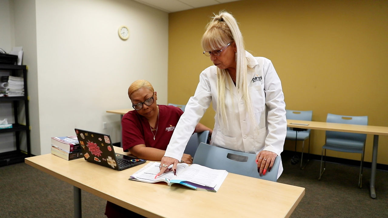 Medical student and instructor reviewing textbook together