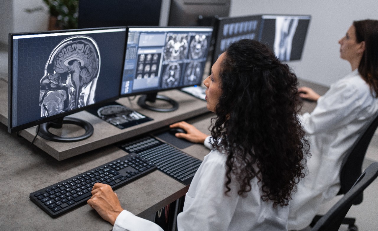 Doctors working with computer and analyzing medical scans. Examination at specialized medical clinic, diagnosis and healthcare concept.