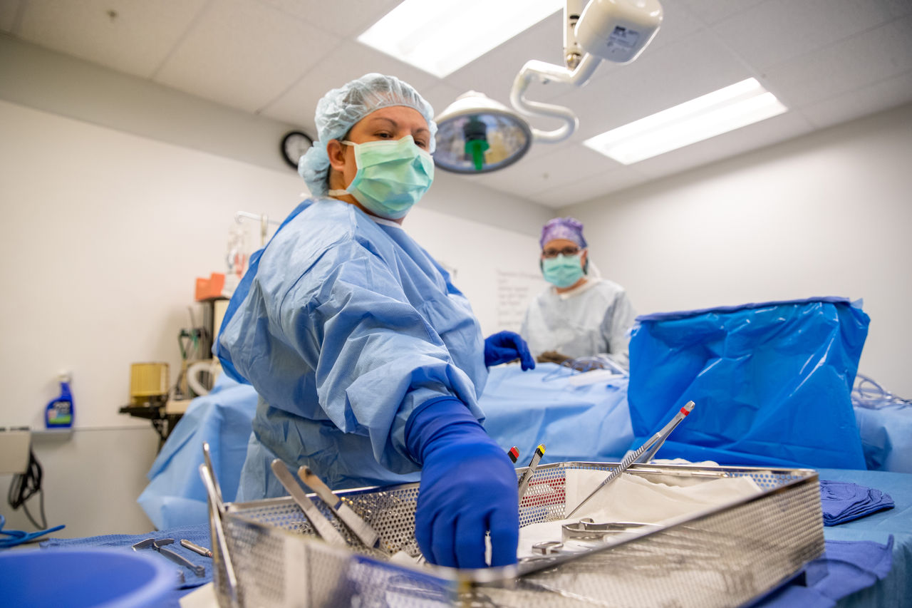 Surgeons preparing instruments in operating room setting