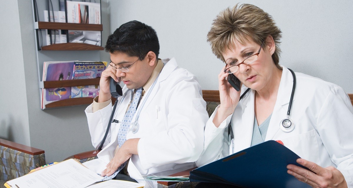 Doctors sitting in room with telephones