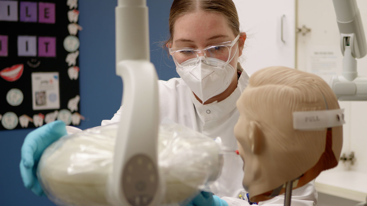 Dental student practices on mannequin in clinical lab