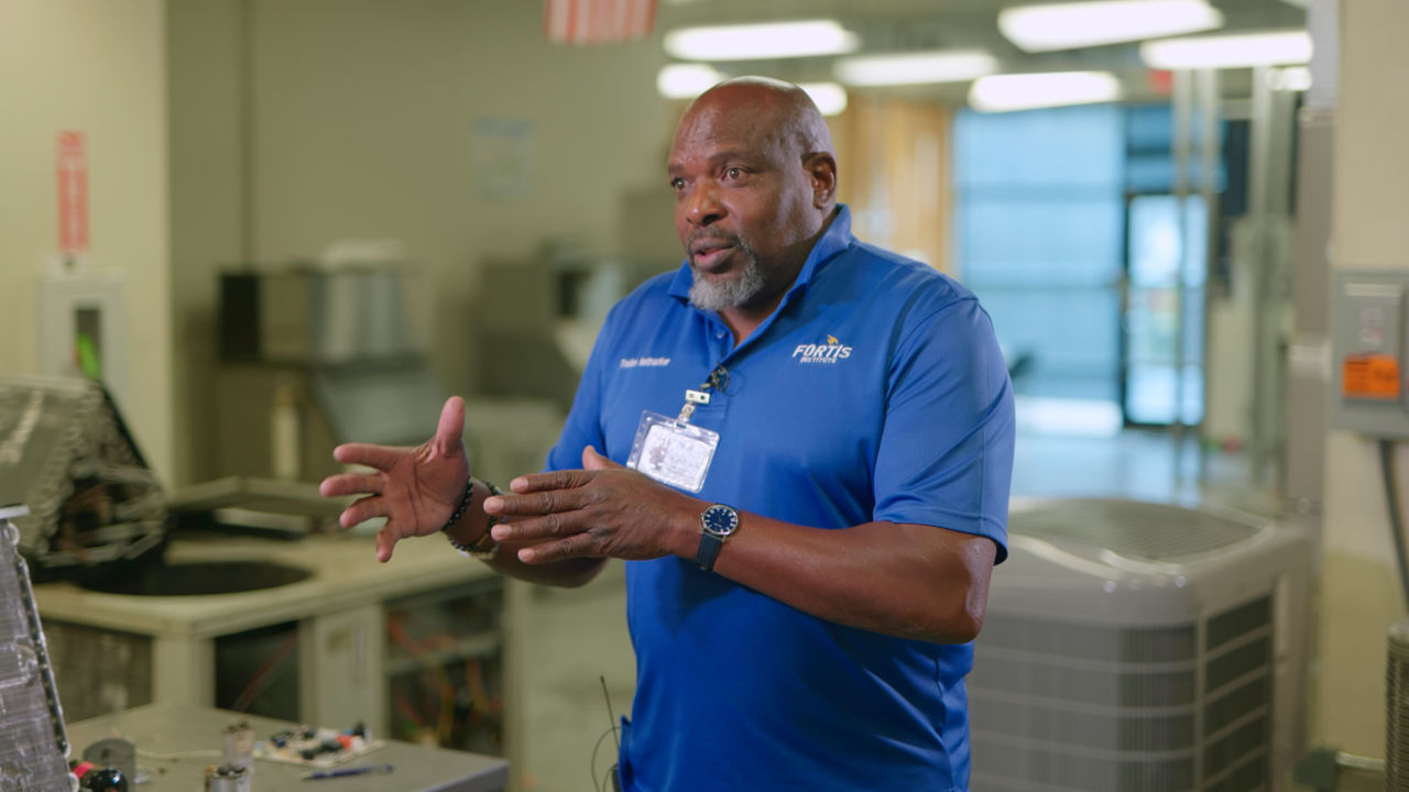 Technician explaining HVAC equipment in workshop setting