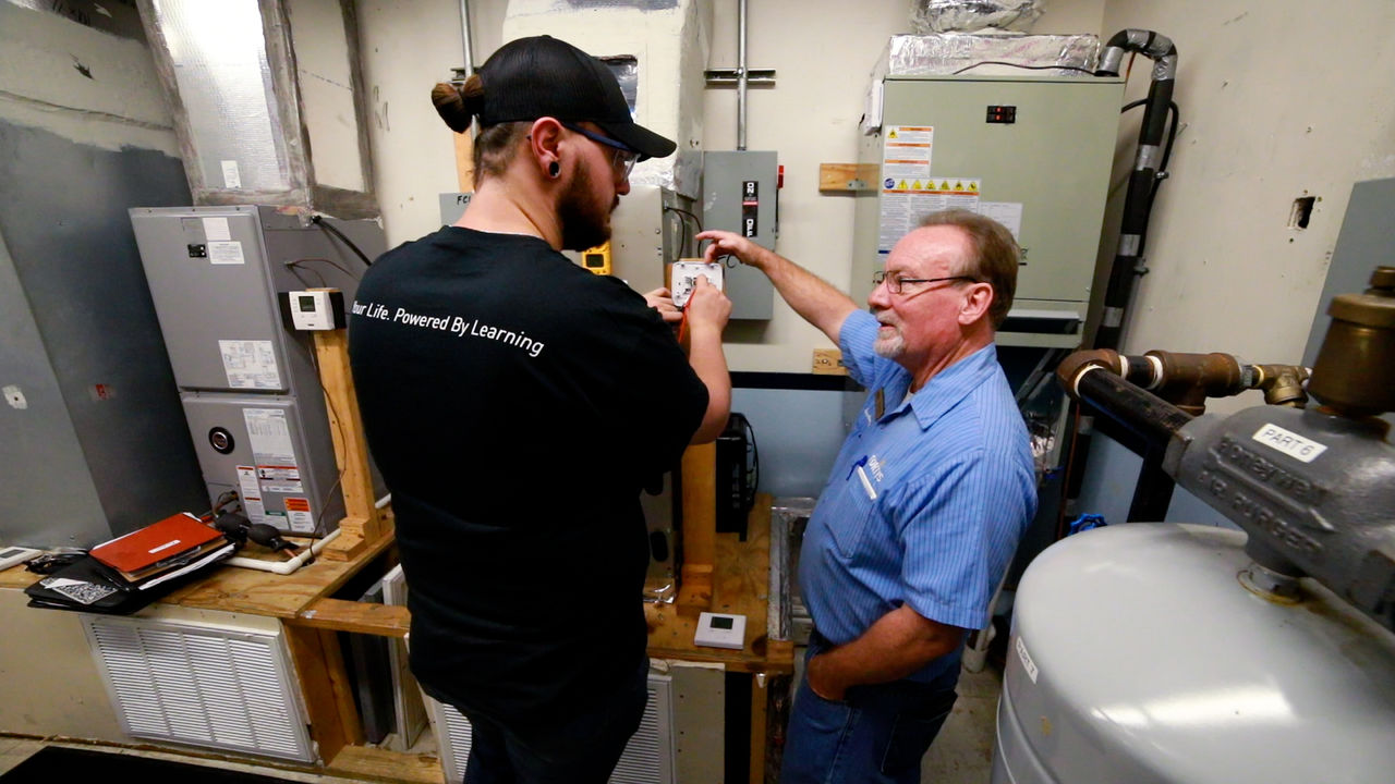 Technicians Inspect Electrical Panel in Utility Room