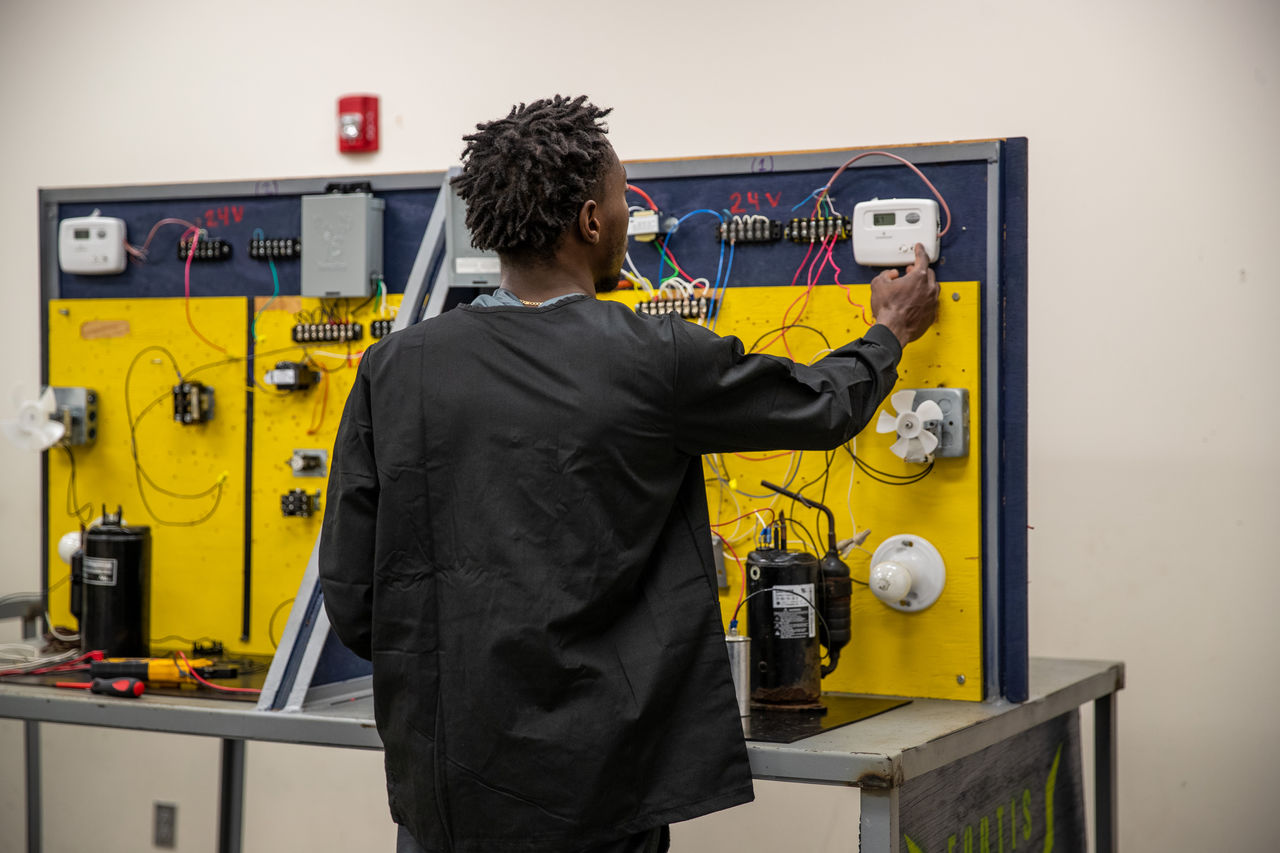 Student Adjusts Controls on Electrical Training Board