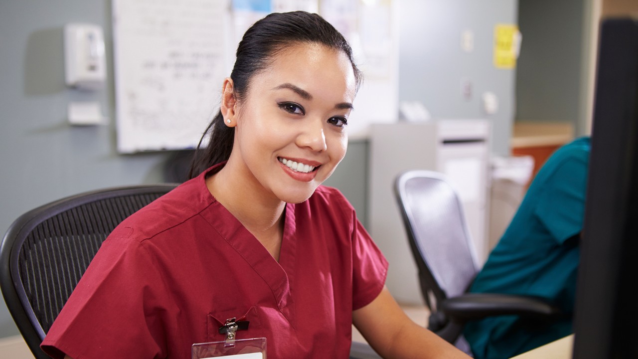 Portrait Of Female Nurse Working At Nurses Station